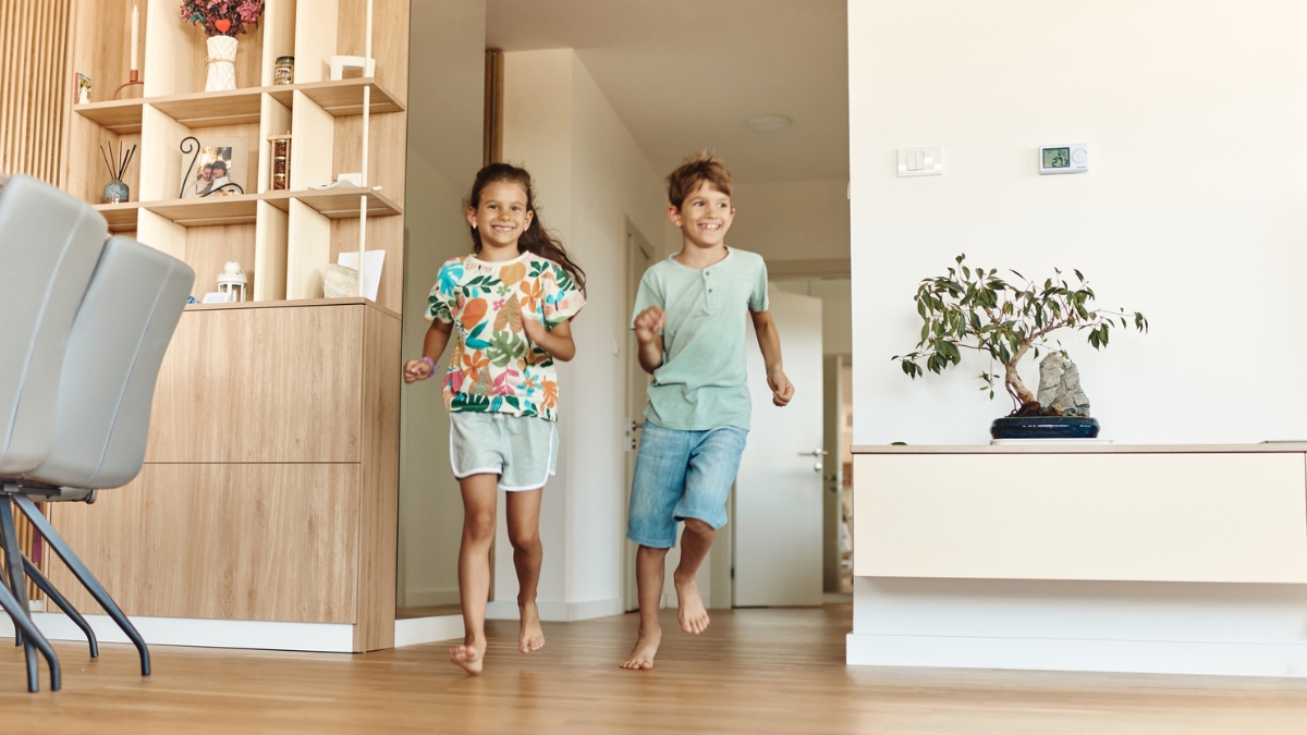 Kids enjoying a clean hardwood floor after detailed residential deep cleaning.